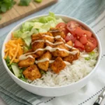 Buffalo Chicken Rice Bowl with vibrant toppings and a drizzle of ranch dressing.