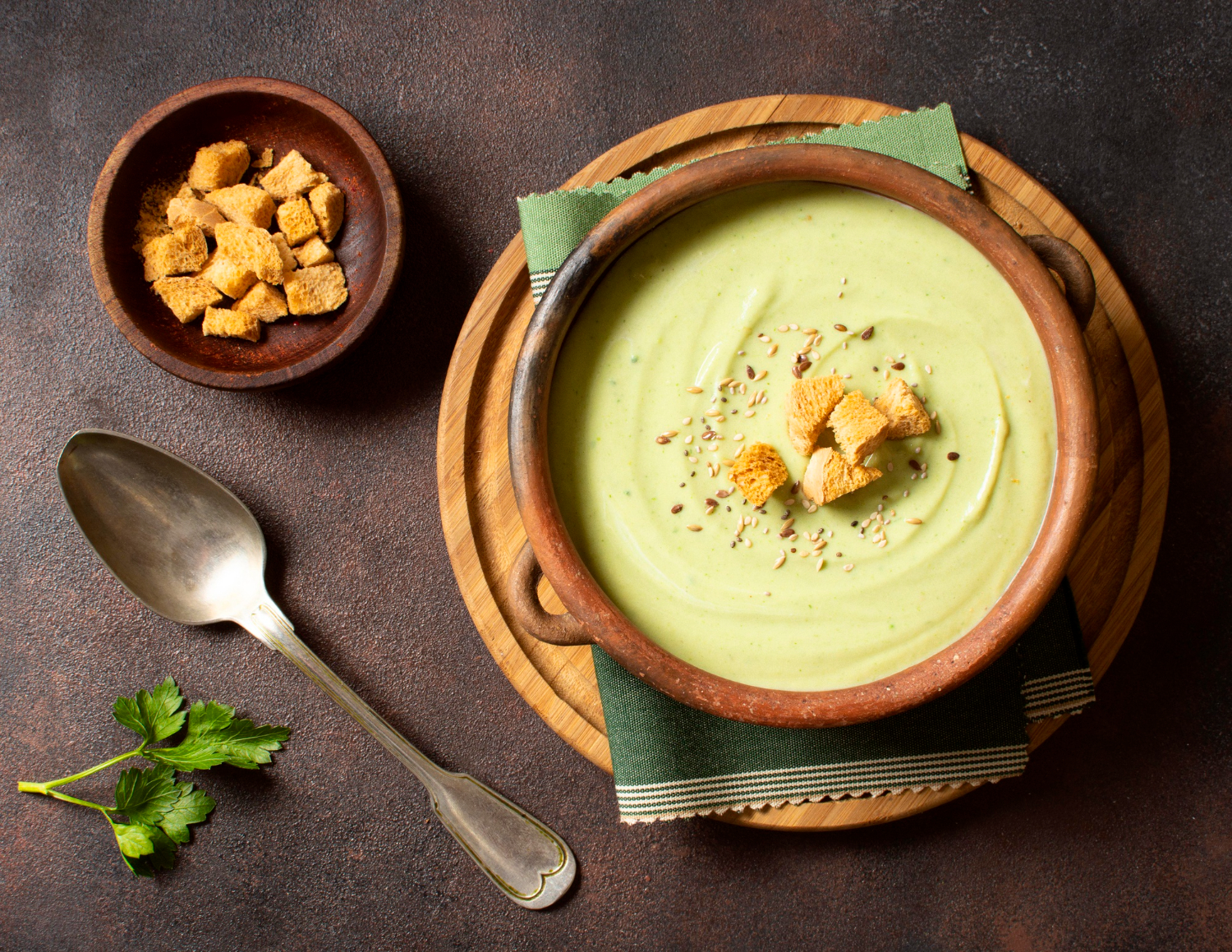 Delicious creamy brown artichoke soup served in a white bowl, garnished with crispy bread croutons.
