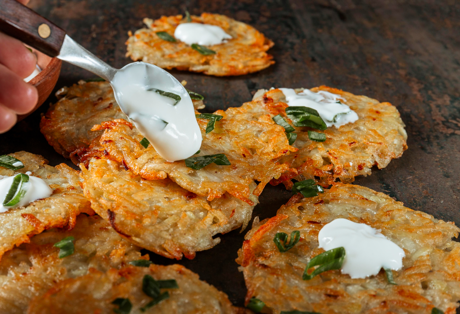 Golden-brown cottage cheese potato cakes served on a white plate with fresh parsley garnish